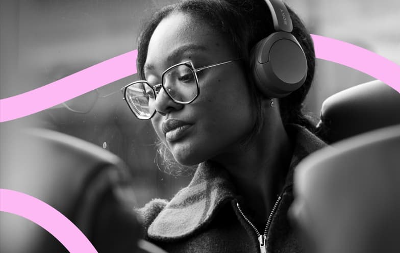 Woman wearing headphones and glasses, seated on a bus with pink curved lines overlaid