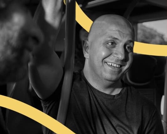 Man holding onto a pole, with yellow curved lines overlaid